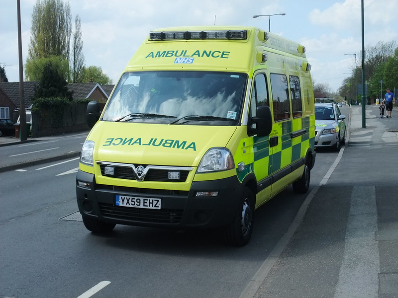 An NHS ambulance driving along a road